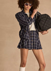 THE UPSIDE women's check Valencia Jones Pleated Skirt is true to size with structured waistband, belt loops, and antique brass button closure at centre front. Made for lifestyle.