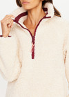 THE UPSIDE women's natural recycled polyester Harlow Fleece Pullover has a relaxed fit with a striped rib collar, contrast maroon stripes, and zip pockets. Made for lifestyle