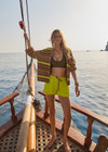 THE UPSIDE women's green recycled polyester Lucky Run Short is designed for a true-to-size fit and features a slightly curved hem with inner short for full coverage. Made for running.