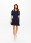 THE UPSIDE women's navy tennis Plume Knit Collared Dress fits true-to-size and features a drop waist with gathered skirt and a drawcord with tennis charms.
