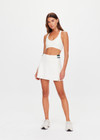 THE UPSIDE women's cream recycled soft peached Courtship Becket Mini Skirt is a panelled tennis skirt featuring an internal short external pockets with contrast striped elastic detailing at waistband. Made for tennis, gold & pickleball.