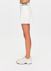 THE UPSIDE women's cream recycled soft peached Courtship Becket Mini Skirt is a panelled tennis skirt featuring an internal short external pockets with contrast striped elastic detailing at waistband. Made for tennis, gold & pickleball.
