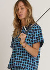 THE UPSIDE women's navy and blue plaid cotton Clubhouse Dom Polo Shirt is a relaxed fit and features a knitted collar with cream crochet detailing on edge. Made for tennis, golf & pickleball.