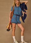 THE UPSIDE women's navy and blue plaid cotton Clubhouse Reece Mini Skirt is designed as a faux wrap skirt featuring a soft elastic waistband and a curved hemline. Made for tennis, golf & pickleball.