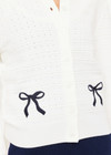 THE UPSIDE women's cream Jolie Isabeli Knit Cardigan is a regular fit with a blouson sleeve crafted from a pointelle knit and features navy embroidered bows. Made for tennis, golf & pickleball.