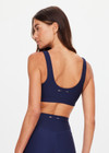 THE UPSIDE women's navy eco tech Toscan Harley Scoop Sports Bra is designed for mid coverage with a scoop front and back neckline, featuring removeable cups and crafted with contrast mocha and cream binds. Made for yoga & pilates.