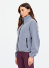 THE UPSIDE women’s grey recycled Sol Fleece Jacket has a relaxed fit with elastic waist and arm cuffs with polar fleece fabrication in marle. Made for lifestyle.