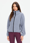 THE UPSIDE women’s grey recycled Sol Fleece Jacket has a relaxed fit with elastic waist and arm cuffs with polar fleece fabrication in marle. Made for lifestyle.