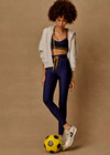 THE UPSIDE women’s navy recycled Eco Tech Salvador 25inch Midi Legging is mid rise and features side seam pockets, a cuffed hem and drawcord waist. Made for yoga and pilates.
