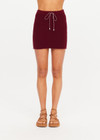 THE UPSIDE women's maroon organic cotton Zelma Knit Mini Skirt is a true to size fit with contrast side stripe detailing and an adjustable drawcord waist. Made for lifestyle.