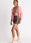 THE UPSIDE women's chocolate Rhythm 5inch Spin Short is mid-rise and features cream and light green binds along side seams in our recycled rib fabrication. Made for yoga and pilates.