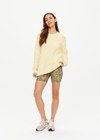 THE UPSIDE women's butter yellow Boo Cable Knit Sweater is made with organic cotton and features a patch pocket at chest and ribbed cuff, neck, and hem.