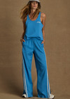 THE UPSIDE women's bright blue Juliet Low Waist Trackpant is made from a slinky, lightweight fabric and feature side stripes, pockets and a split flared hem.