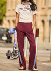 THE UPSIDE women's maroon Ryder Petra Flare Trackpant feature blue side stripes, a split hem, elasticated waist and side pockets.