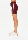 THE UPSIDE women's maroon Trail 6 inch Spin Short is made from soft, breathable fabric and features contrast butter yellow side stripe and an elastic waist.
