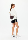 THE UPSIDE women's recycled fabric black and chocolate check Technica Voyage Crossbody Bag features multiple pockets with zippers, plus an adjustable and removable stripe strap.