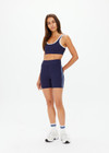 THE UPSIDE women's navy Silverstone 5 Inch Spin Short is a recycled textured rib fabrication with moisture wicking properties. Made for a soft & supportive fit in yoga and pilates.