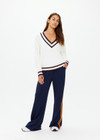THE UPSIDE women's white organic cotton Josette V Neck Knit Sweater features a striped cable neckline in orange and navy. Made for everyday leisure.