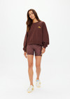 THE UPSIDE women's cocoa organic cotton Paloma Crew features an oversized fit with printed yellow logo on the chest. The perfect lifestyle piece to add to your wardrobe.