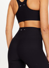THE UPSIDE women's black Peached Florence Flare is a high-rise full length flare pant with V waistband and a printed arrow logo on back waistband.
