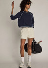 THE UPSIDE women’s cream cotton Penny Tilly Short is a low-rise style with a structured waistband and branded tortoiseshell button closure. Made for everyday wear.