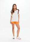 THE UPSIDE women’s cream cotton Elixir Seven Tee is designed for a relaxed fit and features orange and navy stripes on neckline and shoulders. Made for everyday wear.