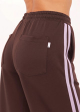 THE UPSIDE women's brown Roma Pant features a high rise with an elasticated waistband, pockets, and a side stripe with lilac mesh. Made from recycled double faced single jersey fabrication. Made for lifestyle.