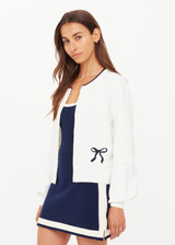 THE UPSIDE women's cream Jolie Isabeli Knit Cardigan is a regular fit with a blouson sleeve crafted from a pointelle knit and features navy embroidered bows. Made for tennis, golf & pickleball.