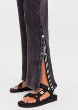 THE UPSIDE women's washed black Cosmic Wide Leg Shana Pant is a high waisted, wide-leg fit and features silver metal button snaps down leg that can be worn open.