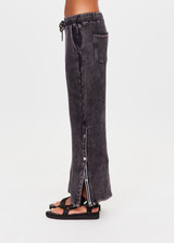 THE UPSIDE women's washed black Cosmic Wide Leg Shana Pant is a high waisted, wide-leg fit and features silver metal button snaps down leg that can be worn open.