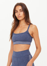 THE UPSIDE women's blue Bowery Baxter Tbar Sports Bra features a scooped neckline with ultraflex recycled fabrication, removeable bust cups and cream embroidered stripes at underbust. Made for yoga & pilates.