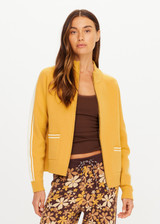 THE UPSIDE women's yellow organic cotton Bonito Dylan Knit Jacket offers a relaxed fit and features raglan sleeves, front patch pockets and contrast stripe detailing. Made for lifestyle.