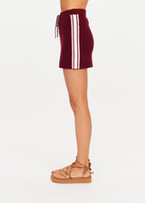 THE UPSIDE women's maroon organic cotton Zelma Knit Mini Skirt is a true to size fit with contrast side stripe detailing and an adjustable drawcord waist. Made for lifestyle.