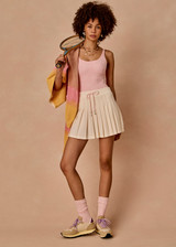 THE UPSIDE women’s cream recycled Cadiz Pleated Skirt is designed for a true to size fit and features a pleated design, built in inner short with pockets and drawcord detail. Made for tennis.