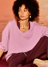 THE UPSIDE women's purple organic cotton Soul Lou V Neck Sweater offers an oversized fit with drop shoulders, ribbed trims and an embroidered logo detail. Made for lifestyle.