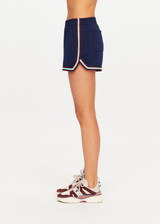 THE UPSIDE women’s navy recycled polyester Cleopatra Short features a mid rise elasticated waistband, curved hem with side splits, back pockets and contrast stripe tape detail. Made for lifestyle.