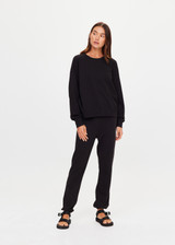 THE UPSIDE women's black organic cotton Lennox Raglan Crew Sweater offers a relaxed fit and features a classic crew neckline, ribbed. cuffs and hem. Finished with a subtle embroidered arrow logo at back. The perfect everyday sweater, made to last.