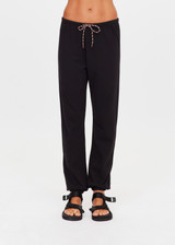THE UPSIDE women's black organic cotton Kayne Track Pant is a classic mid-rise track pant and features a soft elasticated waistband with a brown paracord drawcord, elasticated cuffs and finished with a subtle embroidered arrow logo at back. The perfect everyday track pant, made to last.