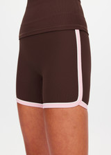 THE UPSIDE women's chocolate Rhythm 5inch Spin Short is mid-rise and features cream and light green binds along side seams in our recycled rib fabrication. Made for yoga and pilates.