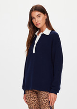 THE UPSIDE women's navy organic cotton Wonder Knit Polo is designed for a relaxed fit and features long sleeves with a contrast cream collar and placket. Made for lifestyle.
