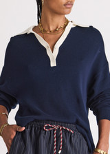 THE UPSIDE women's navy organic cotton Wonder Knit Polo is designed for a relaxed fit and features long sleeves with a contrast cream collar and placket. Made for lifestyle.