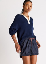 THE UPSIDE women's navy organic cotton Wonder Knit Polo is designed for a relaxed fit and features long sleeves with a contrast cream collar and placket. Made for lifestyle.
