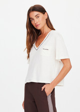 THE UPSIDE women’s natural Elina V Neck Tee is a boxy-fit style featuring a mini chest patch pocket and ribbed neckline with chocolate piping. Made for lifestyle.