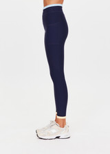 THE UPSIDE women's navy recycled nylon Hermosa 25 Inch Pocket Legging is mid rise and features a contrast hem cuff in butter and pockets at the side. Made for yoga and pilates.