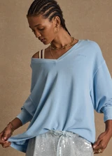 THE UPSIDE women's blue organic cotton Lou V Neck Sweater is an oversized fit and features dropped shoulders and a ribbed neckline and cuffs. Made for lifestyle.