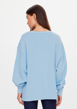 THE UPSIDE women's blue organic cotton Lou V Neck Sweater is an oversized fit and features dropped shoulders and a ribbed neckline and cuffs. Made for lifestyle.