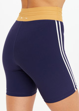 THE UPSIDE women's navy recycled peached Daytona 6 Inch Spin Short is designed for a mid-rise fit featuring contrast cream binds. Made for yoga & pilates.