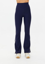 THE UPSIDE women's navy recycled peached Florence Flare Pant is a high-rise pant in a breathable fabric, featuring cream side stripes. Perfect for pilates.