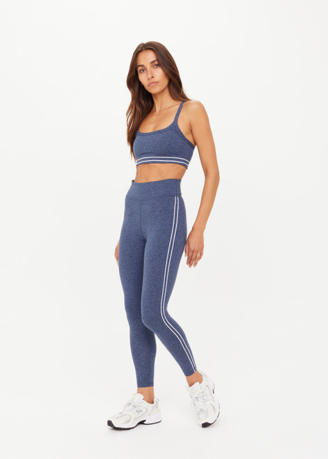THE UPSIDE women's blue Bowery 25Inch Legging features ultraflex recycled fabrication with a mid-rise and cream embroidered stripes down side seams. Made for yoga and pilates.