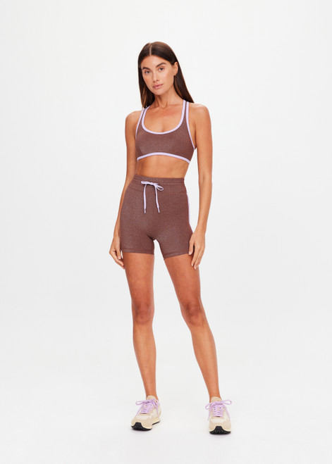 THE UPSIDE women's chocolate metallic Galaxia 4inch Spin Short is mid-rise and features a purple drawcord with aglets and purple rib binds down side seams. Made for yoga and pilates.